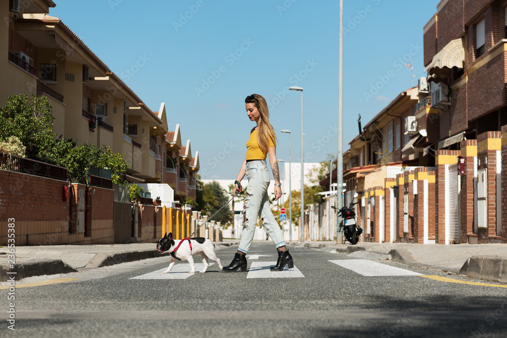 Fashionable woman having walk with dog